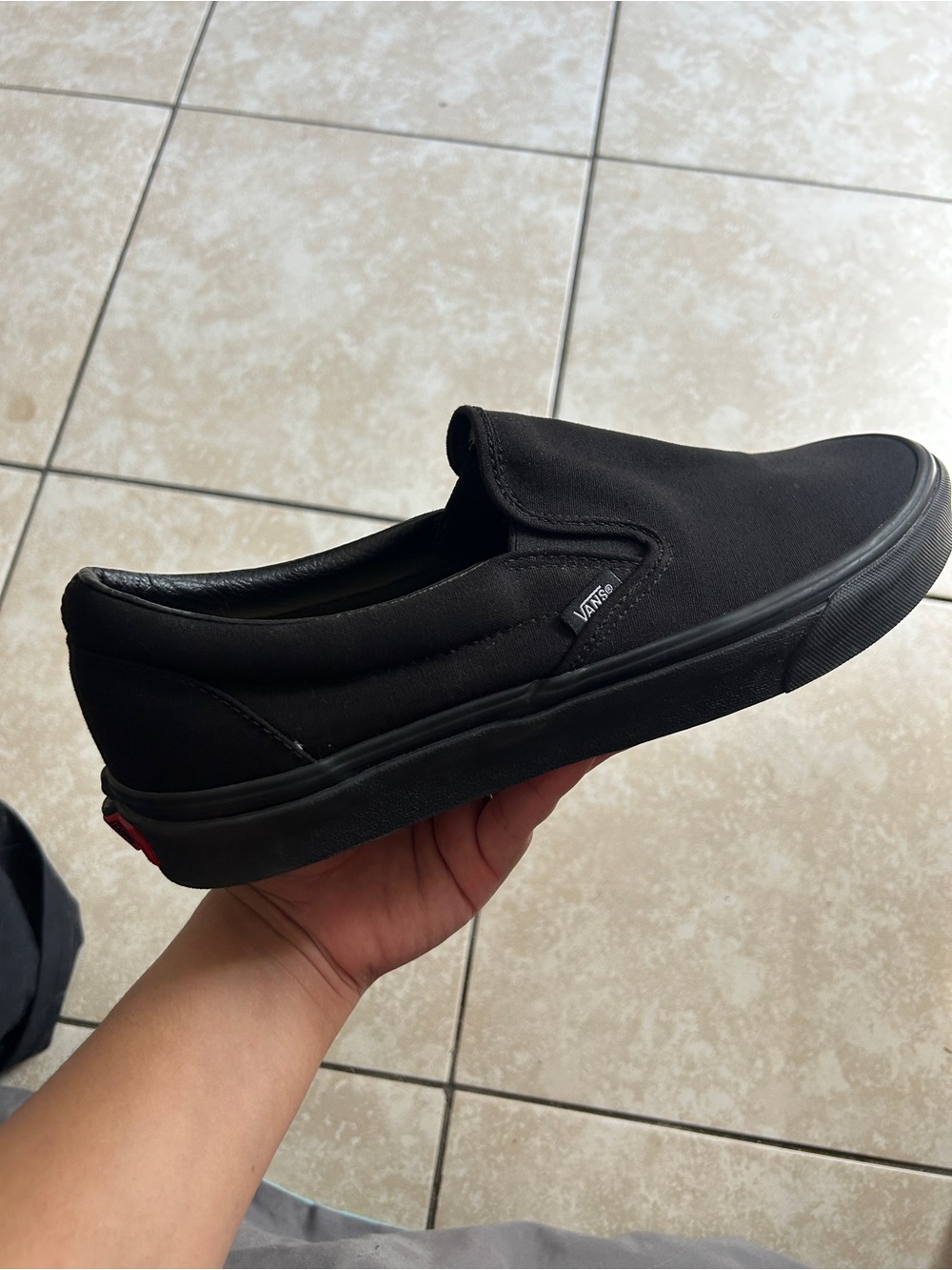 Black Vans slip-on sneakers